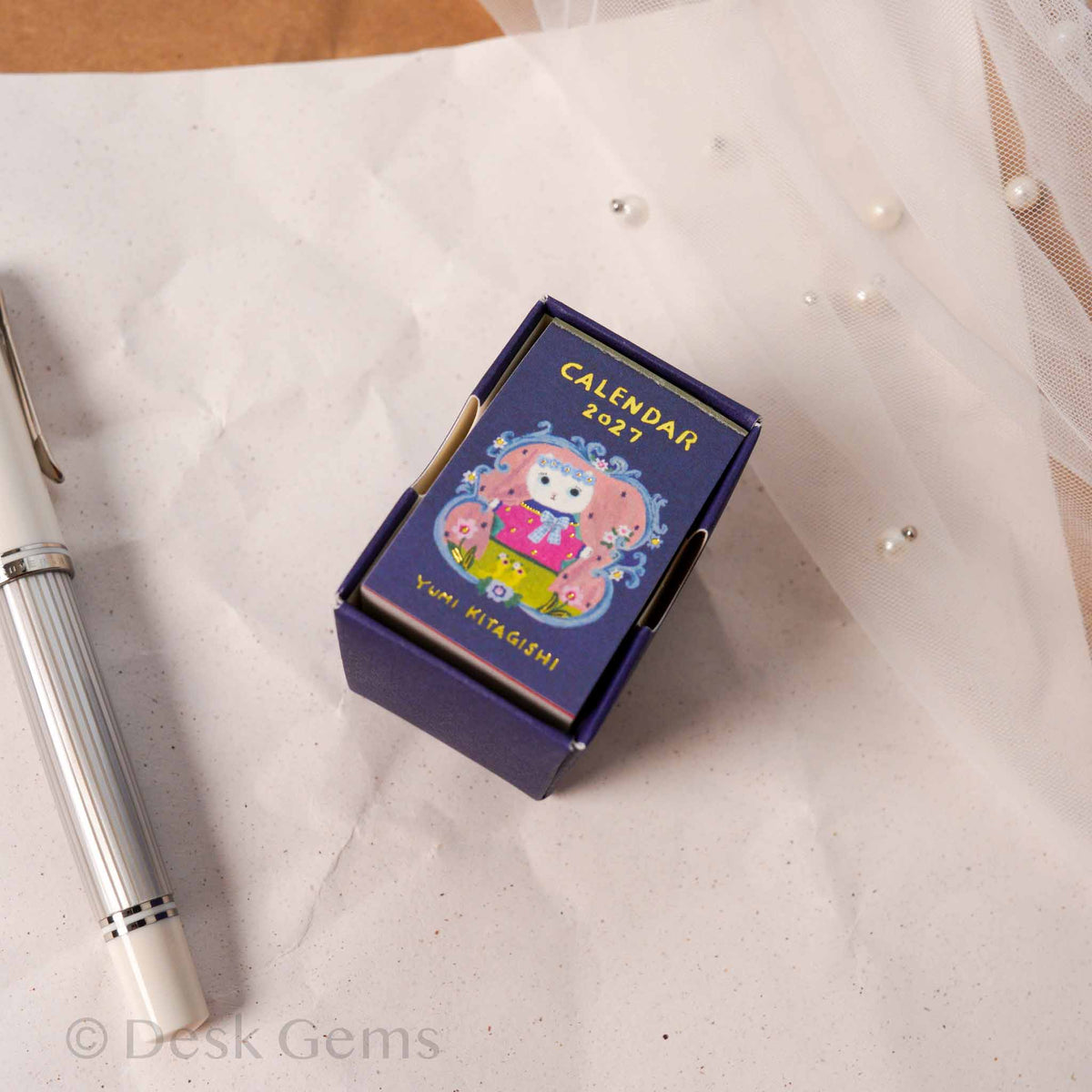 Yumi Kitagishi Mini Mini Daily Calendar 2027 navy box from above showing cat matryoshka illustration