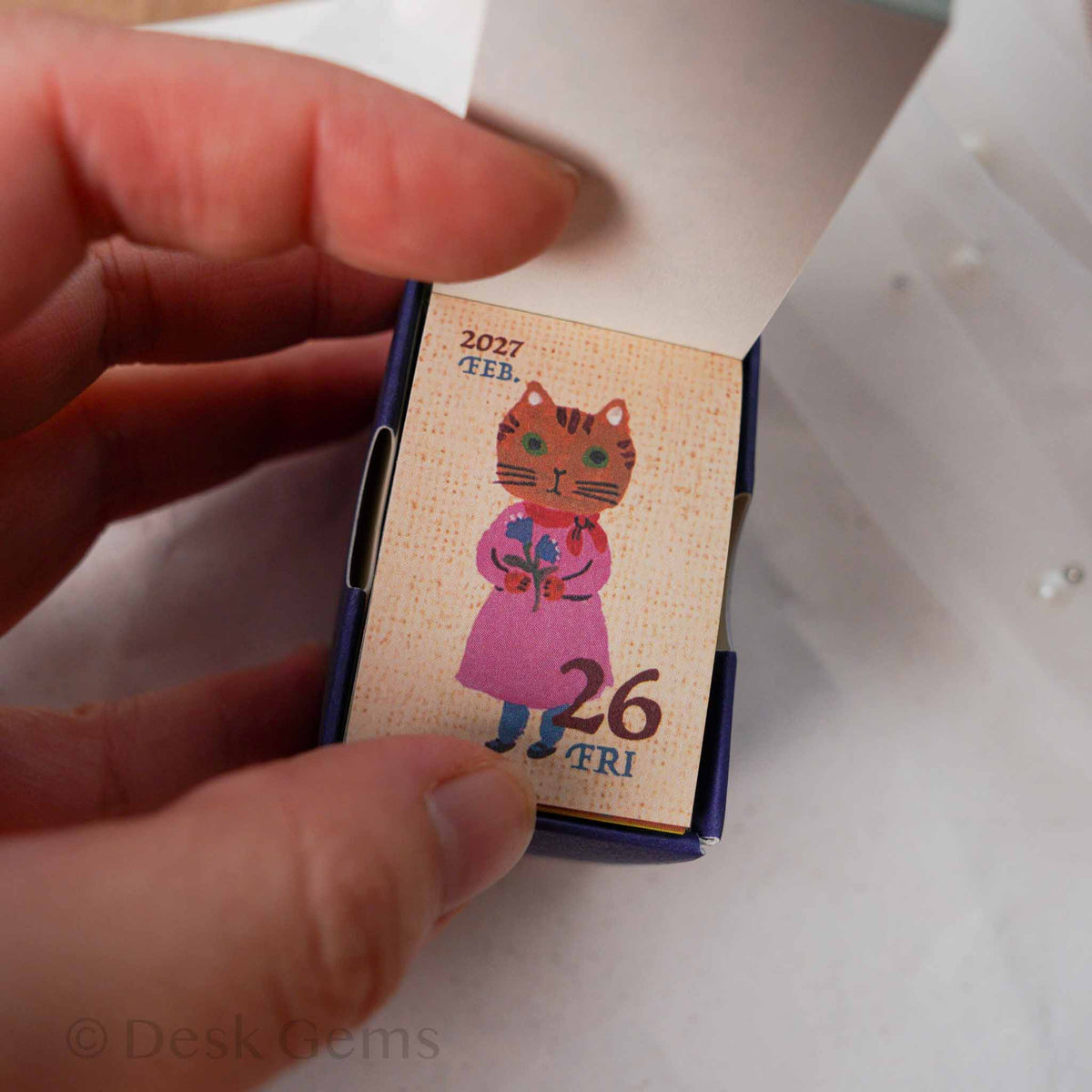 Yumi Kitagishi Mini Mini Daily Calendar 2027 open showing page with cat in pink dress holding flowers