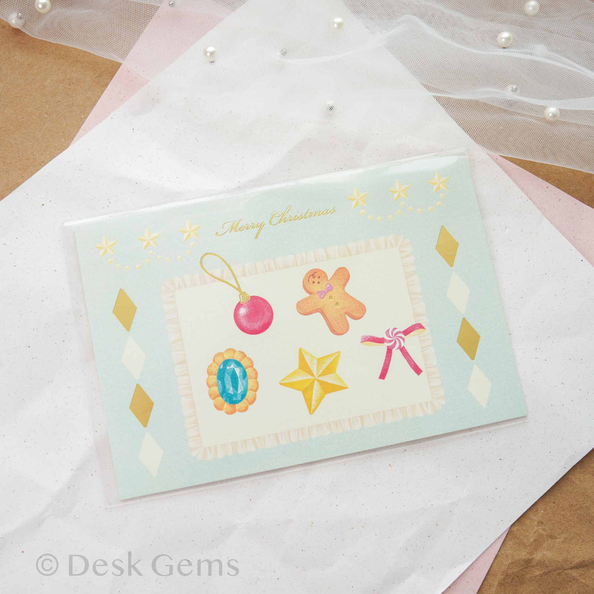 Arakarudo Christmas postcard with festive cookies, ornaments, and gingerbread man on light blue background