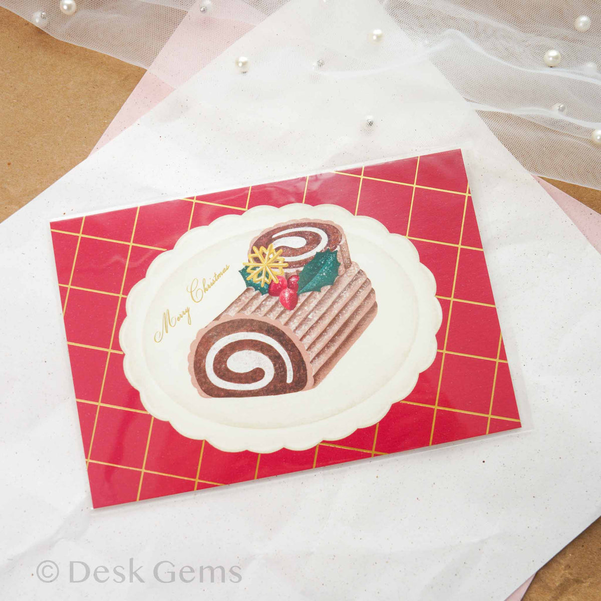 Arakarudo Christmas postcard with Buche de Noel yule log cake on red plaid background