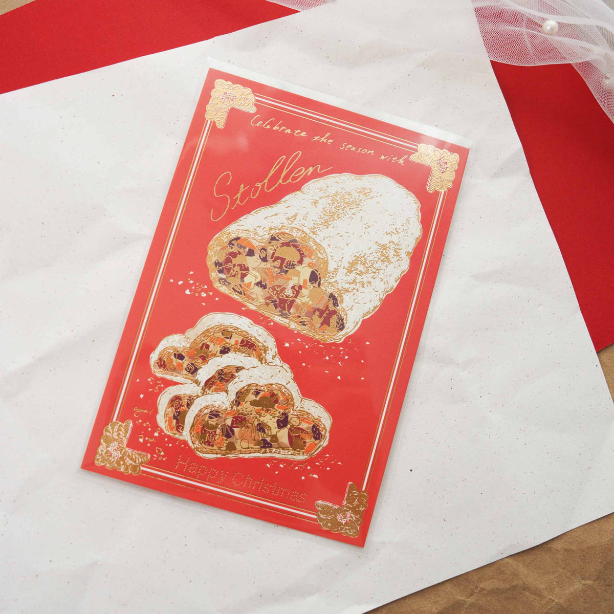 Aya Inoue Christmas postcard with stollen bread on red background