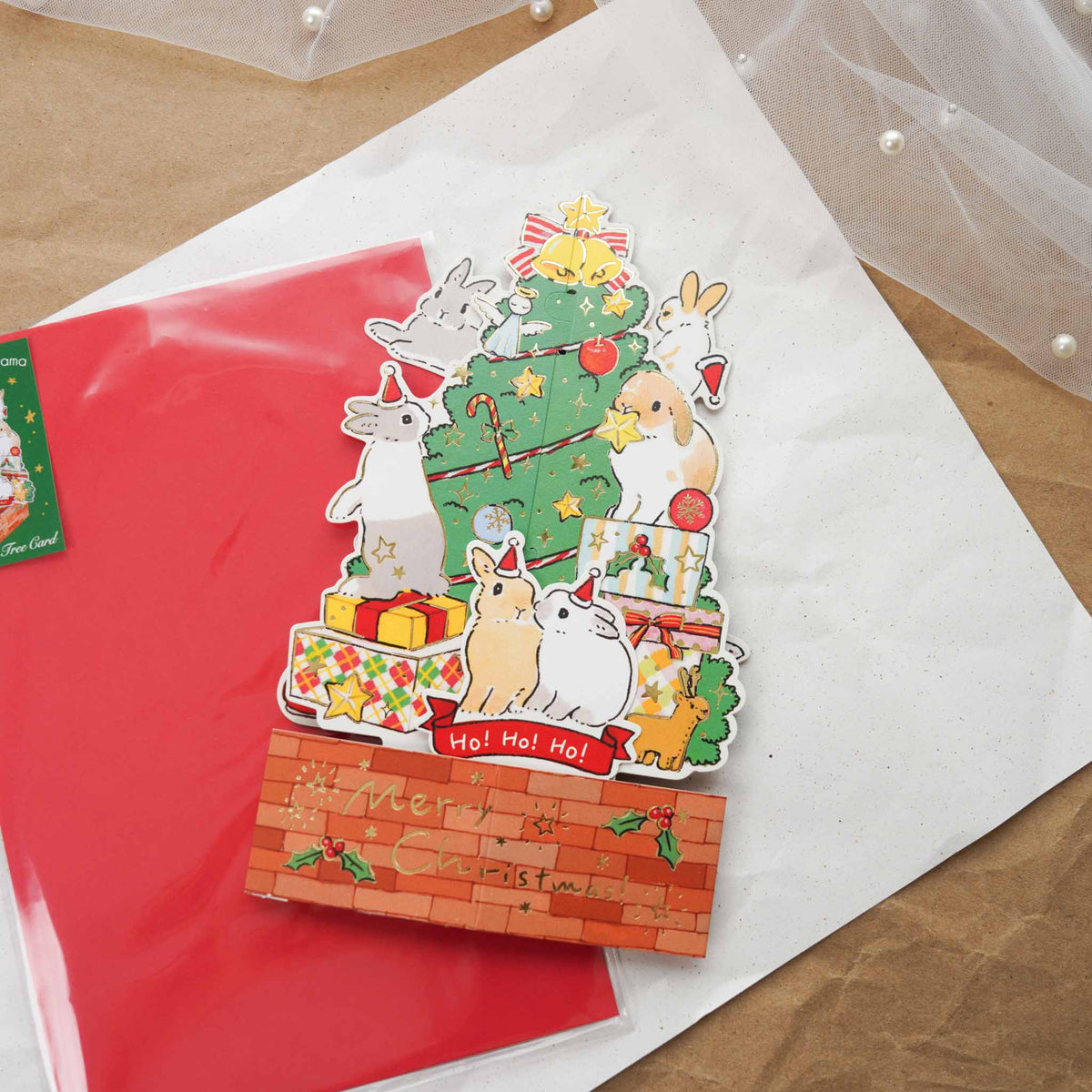 Schinako Moriyama Christmas tree pop-up card standing upright with bunnies decorating the tree