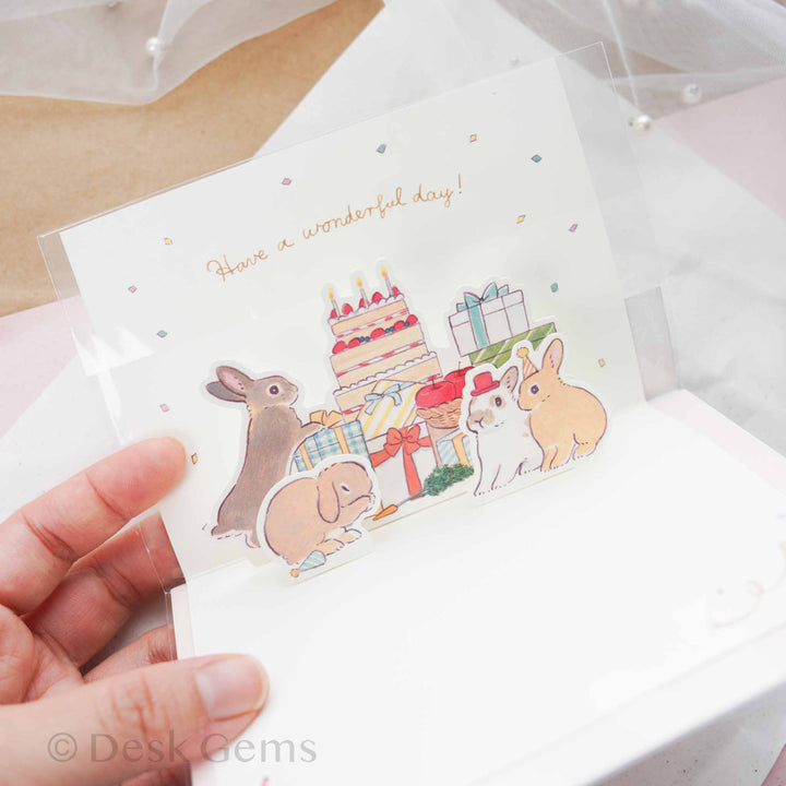 Inside of Schinako Moriyama pop-up birthday card showing pop-up bunnies with cake, presents, and confetti