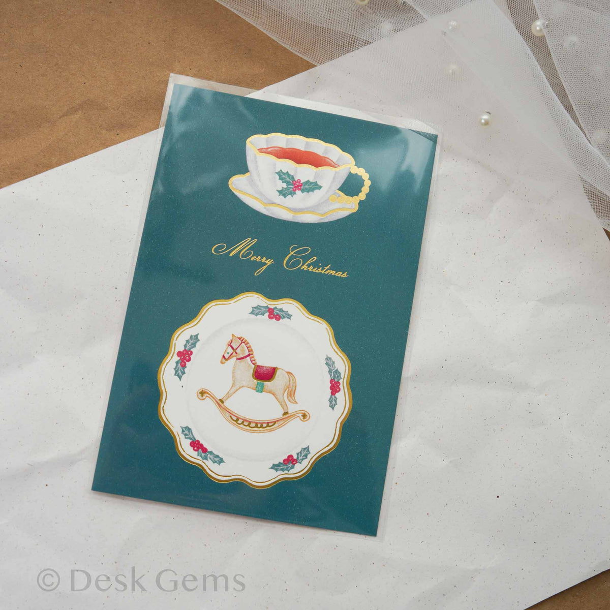 Arakarudo Christmas postcard with a teacup and rocking horse plate on teal background