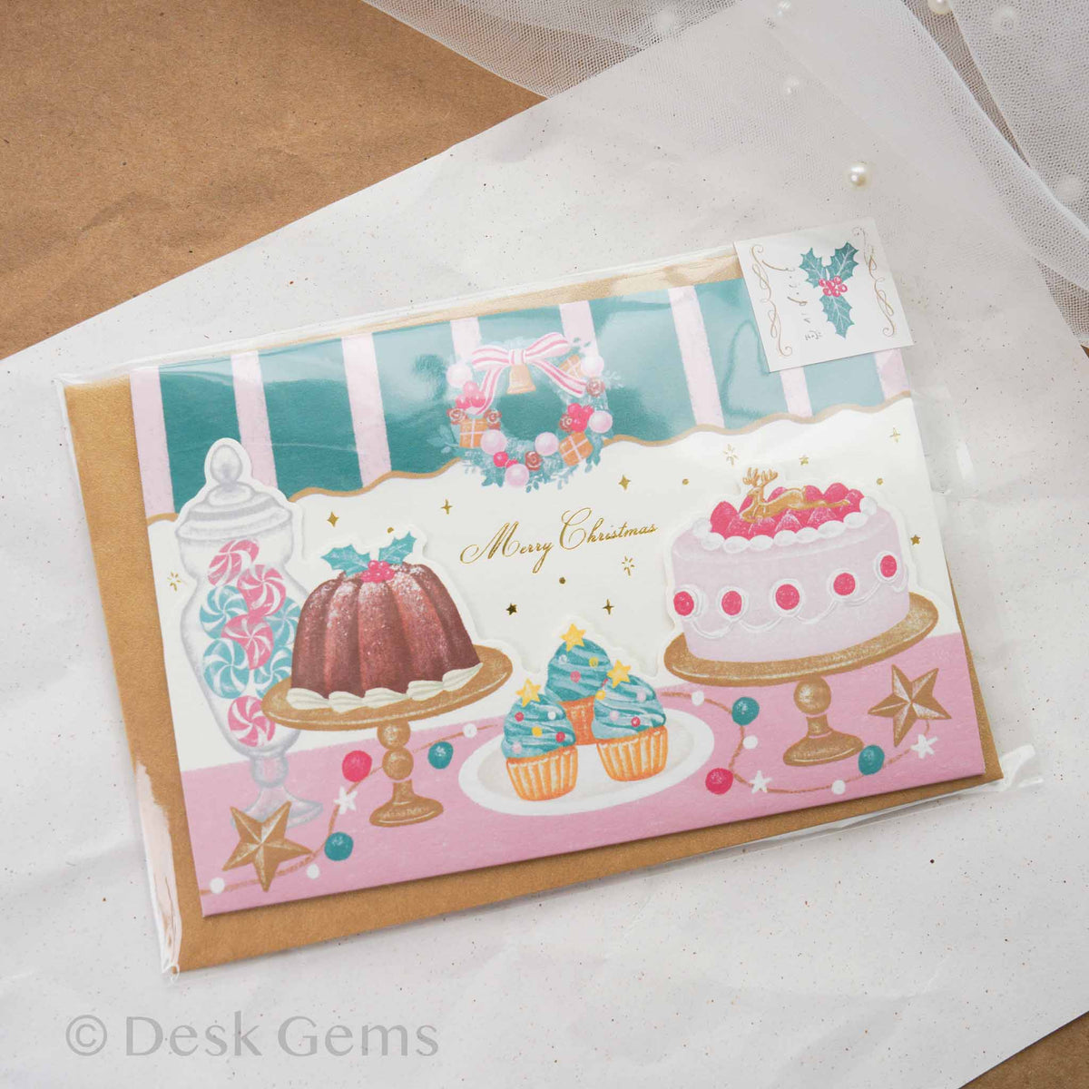 Arakarudo Christmas trifold card front with patisserie scene featuring cakes, cupcakes, and candy jar